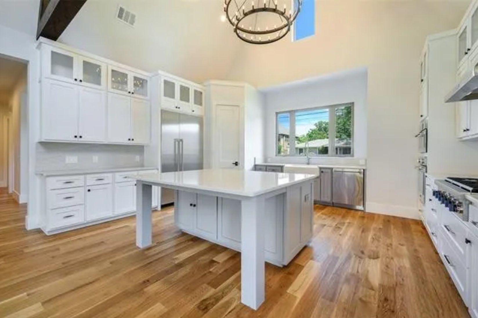 A renovated white kitchen with a full-height island